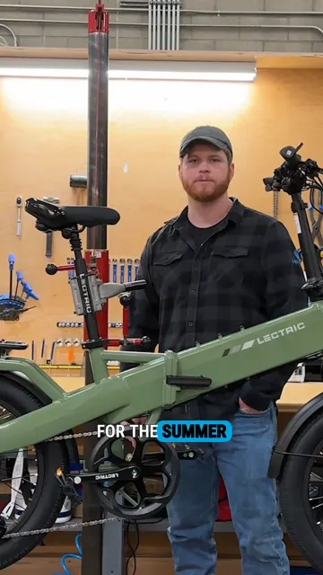 Cover frame of Lectric's top video: a man in a cap stands in a bike workshop holding a green Lectric e-bike, with the words For the summer