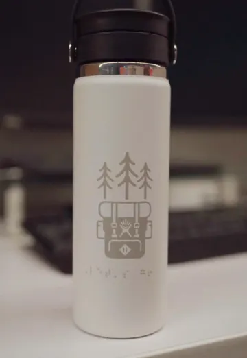 A white Hydro Flask bottle with an engraved design, from Hydro Flask's customization story and its most-viewed recent post.